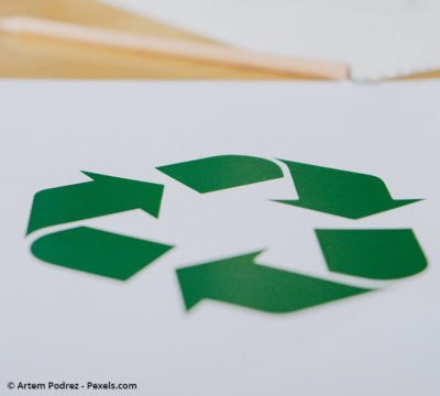 Auf einem Blatt ist das Recycling-Symbol zu sehen. Das Bild stellt die Serviceleistung der Entsorgung dar.
